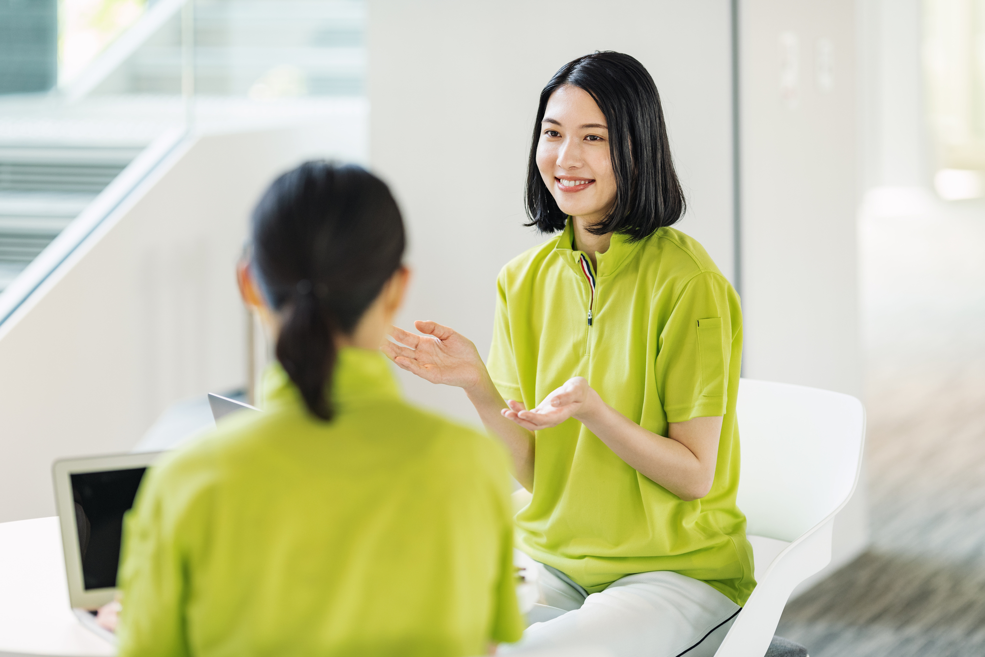 介護施設のスタッフが向かい合って話し合っているイメージ写真